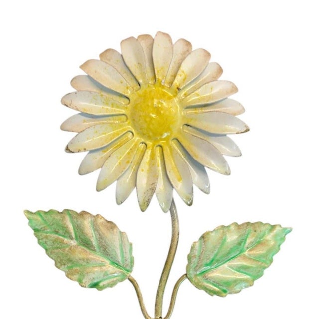 A charming, vintage tole wall hook. Features a ball finial hook accented by a white daisy bloom with a yellow center and a...
