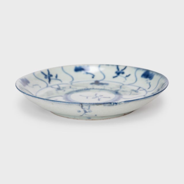 This 19th-century porcelain plate is hand-painted with cobalt underglaze in the blue-and-white manner, loosely brushed...