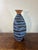 A striking hand-thrown Brazilian studio pottery vase featuring an expressive hand-painted blue and black striped...