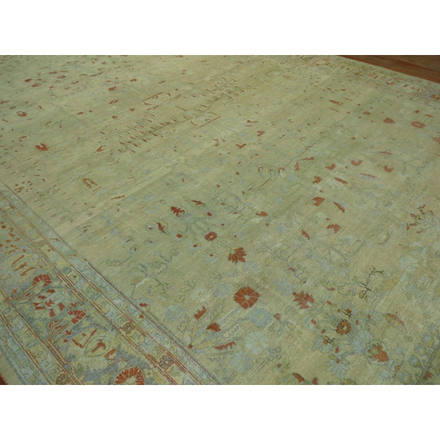 Stunning oversize antique Persian Mohajeran Sarouk rug consisting of a pale wheat ground and powder blue border, some...