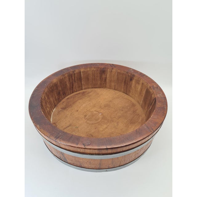 A large, striking bowl made using traditional cooperage techniques from wooden staves, reinforced with two wide metal...