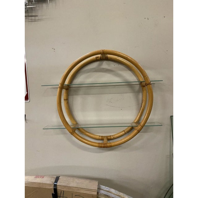 Circular rattan wall self featuring a unique two-strand "Skeleton" design with cut-out sections that hold two glass...