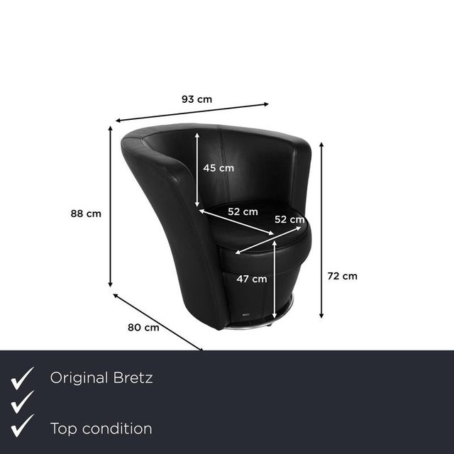 The Eves Island armchair by Bretz is upholstered in black genuine leather and stands on a round metal base. It is...