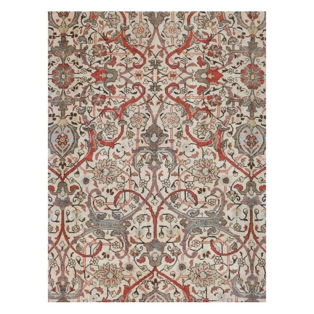 This mid-20th-century Persian Tabriz carpet presents a sophisticated allover floral composition across a warm ivory field....