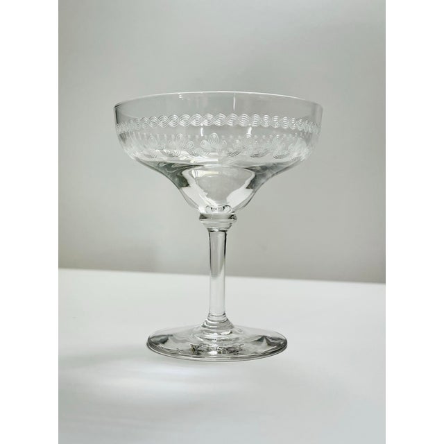 A beautiful cocktail glass hand etched in a pattern reminiscent of cloverleafs and bordered a band of overlapping...