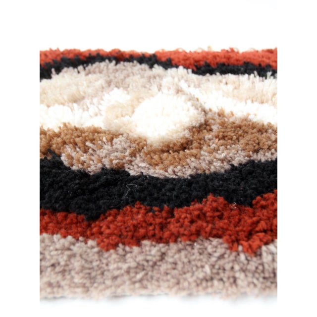 A vintage 1970s latch hook wall hanging featuring an abstract composition of rust, black, cream, taupe, and brown. Plush,...