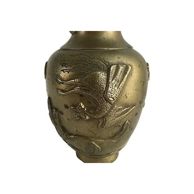 Vintage Chinese brass vase decorated with flying dragons, exotic plants and birds in relief. Maker's mark on underside....