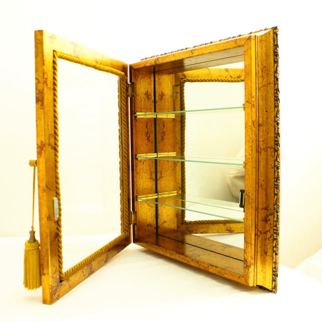 Vintage Italian Gold-Gilt wall Curio Cabinet. Made in Italy by Creazioni Artistiche. Includes three glass shelf's, and...
