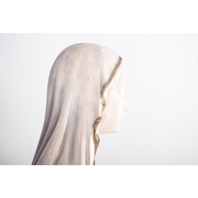 Figure of Our Lady of Lourdes, in Ceramic. The image depicts the Virgin Mary in long robes in shades of white and light...