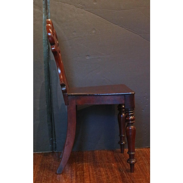 Circa 1860 pair carved hall chairs, English. Mahogany. Raised on boldly turned legs. The backs are of c-scrolled cartouche...
