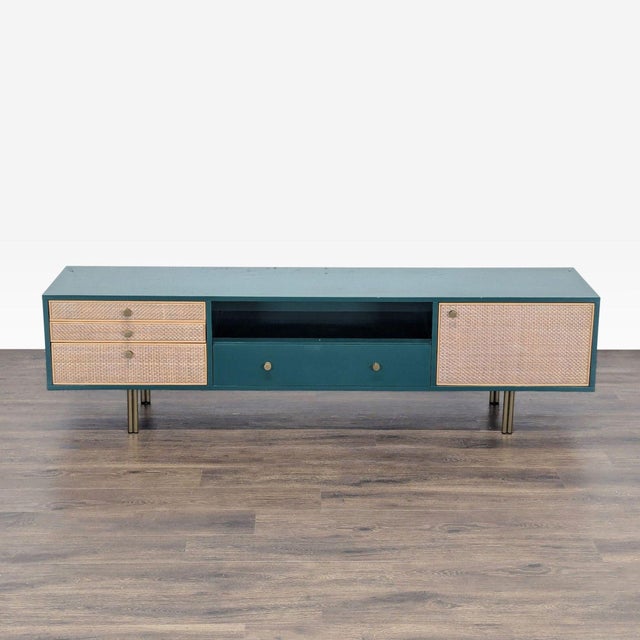 This mid-century-inspired silhouette is defined by a bold veneer façade and textural rattan drawers. It sits on brass...