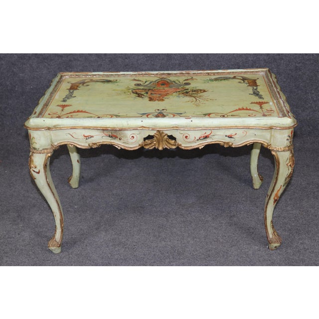 This beautifully distressed Venetian paint–decorated coffee table, dating to the 1930s era, is a charming example of...