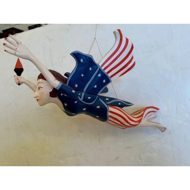 Whimsical hand made carved wood and painted folk art hanging liberty figure.