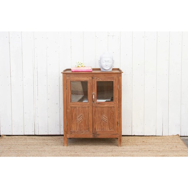 A handsome antique British colonial cabinet with timeless elegance. Constructed from high-quality teak wood, this early...