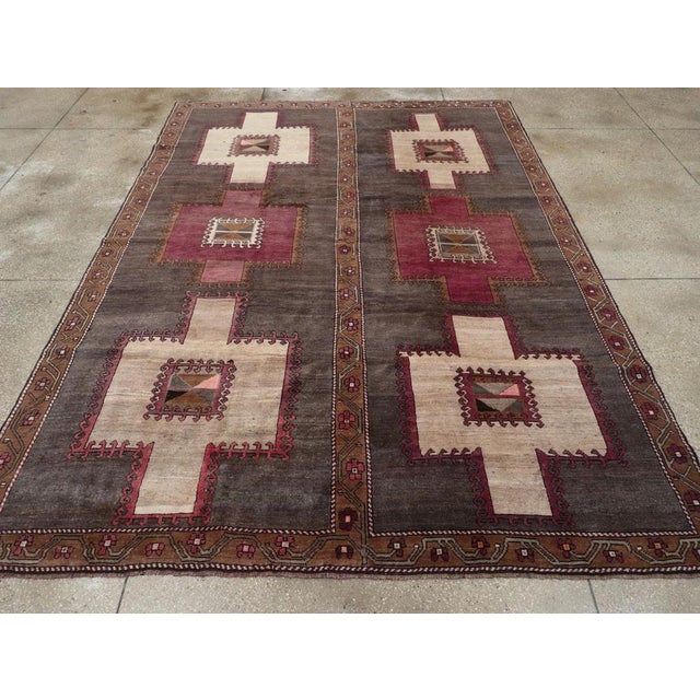 Wool symmetric knots on a wool foundation. The closely abrashed brown field displays two columns of three vertically...