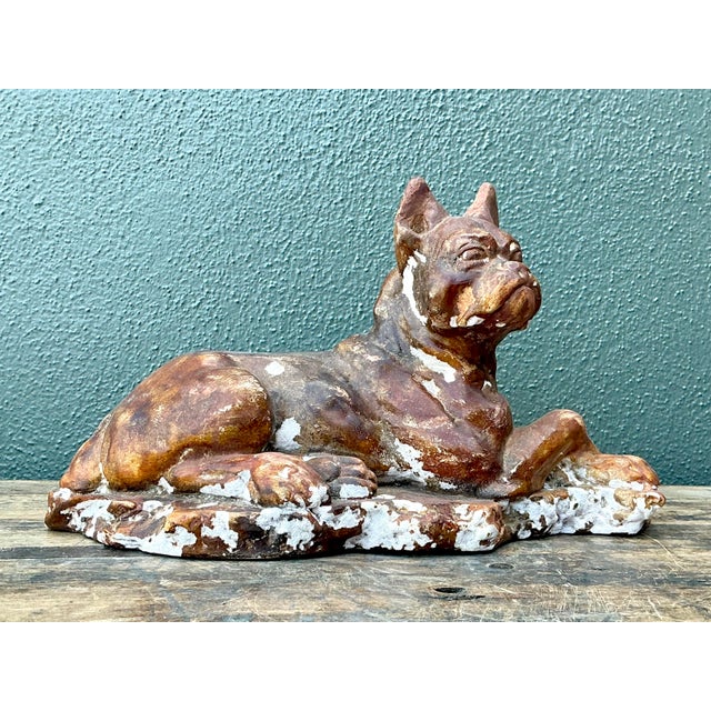 This striking vintage plaster sculpture captures the soulful expression and noble stature of a reclining Boxer dog....