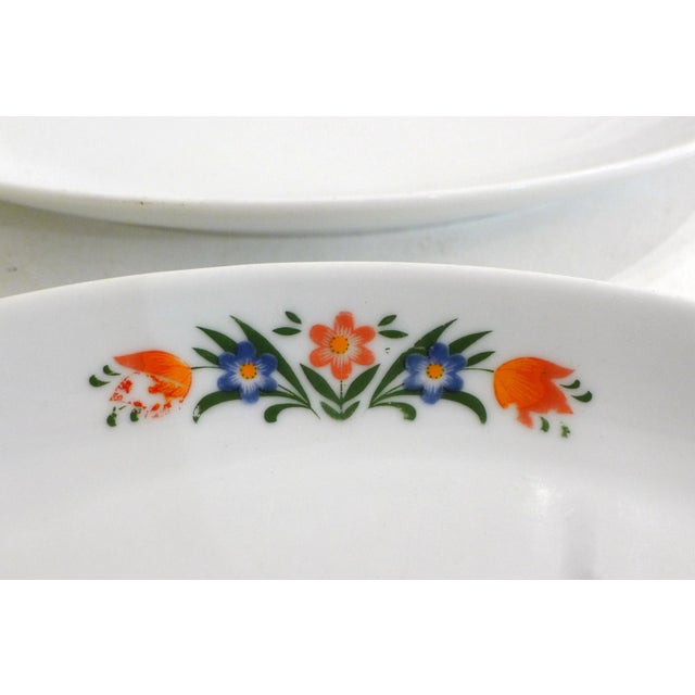 Pair of small oval dishes in white porcelain decorated with stylized colorful flowers; stamp of the factory Winterling...