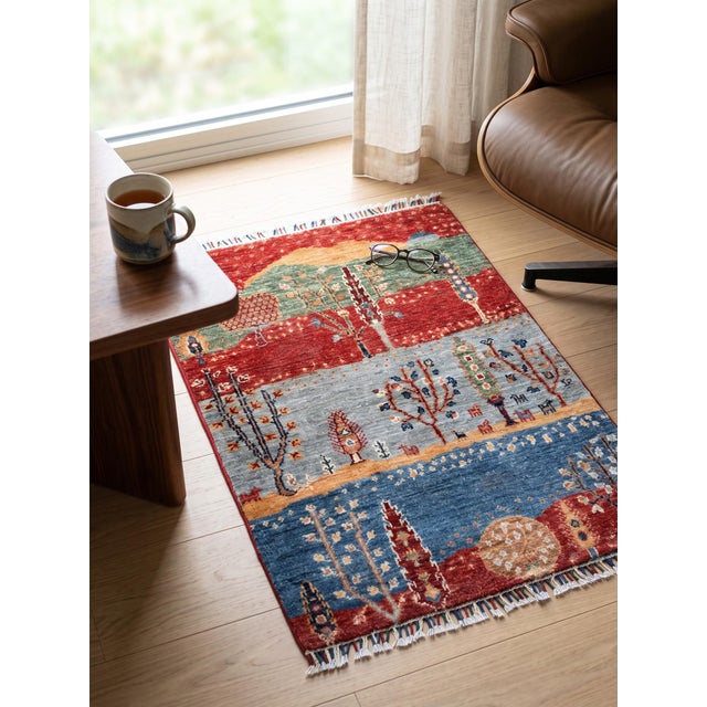 A small hand-knotted Gabbeh rug in the Persian Gabbeh tradition, built up as a landscape in four bands — madder red, sage...