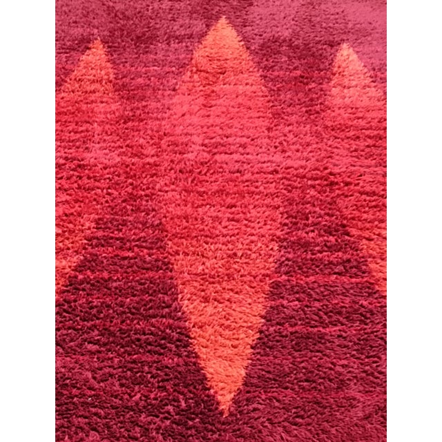 Long pile wool rug with geometric shapes in shades of red, typical of the Space Age style of the 1960s. The rug has been...