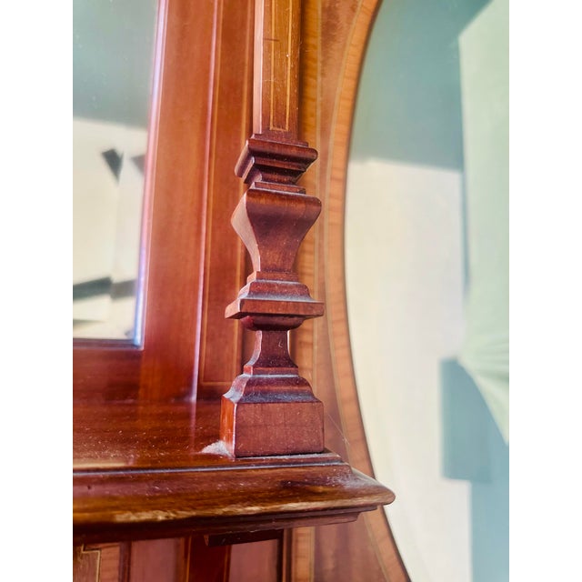 A stunning Sheraton Revival cabinet top featuring a large central oval mirror flanked by two rectangular mirrors. This...