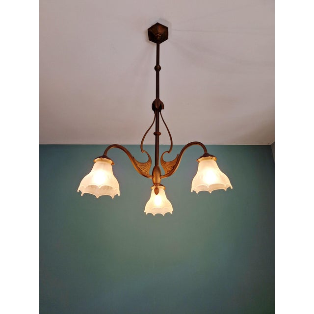 Art Nouveau brass chandelier with three arms and scalloped frosted glass shades, circa 1900-1910. Compatible with B22 LED...
