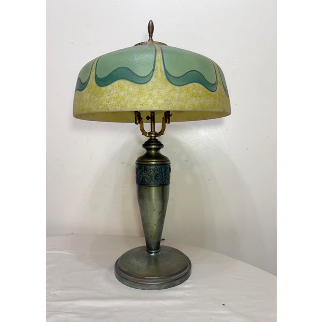 This Antique Art Deco Pittsburg table lamp is a unique and elegant piece from the 1920s. The lamp features a beautiful...