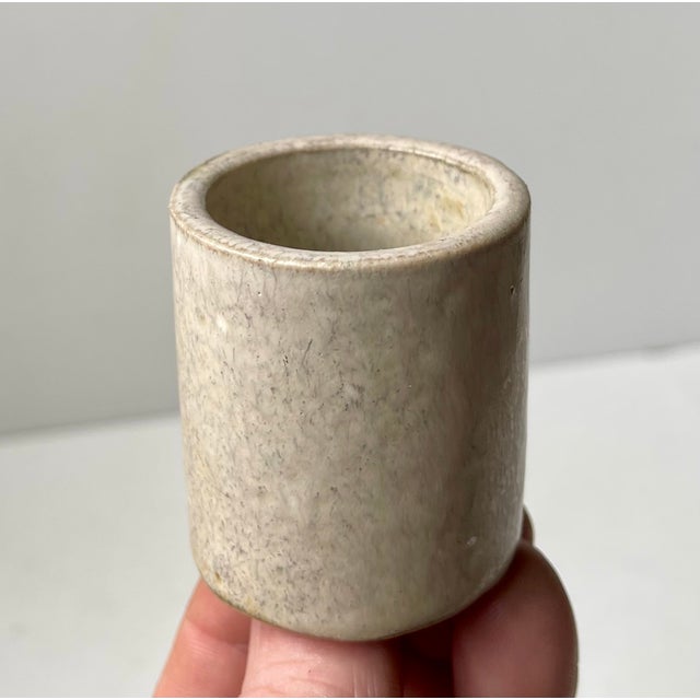 Small cylindrical stoneware vase decorated with sand-colored glaze. It was designed by Arne Bang in his own workshop in...