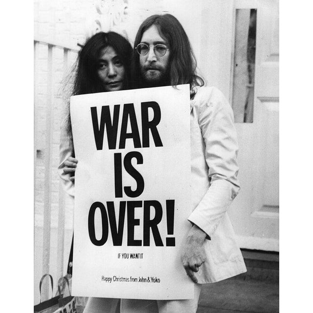 War Is Over John Lennon (1940 - 1980) and Yoko Ono pose on the steps of the Apple building in London, holding one of the...