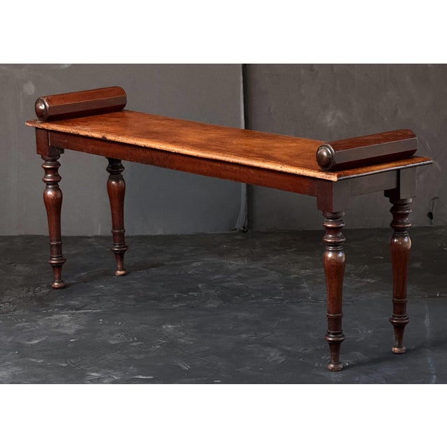 A fine English hall bench or window seat or stool of mahogany from the Regency era, featuring turned handles at opposing...