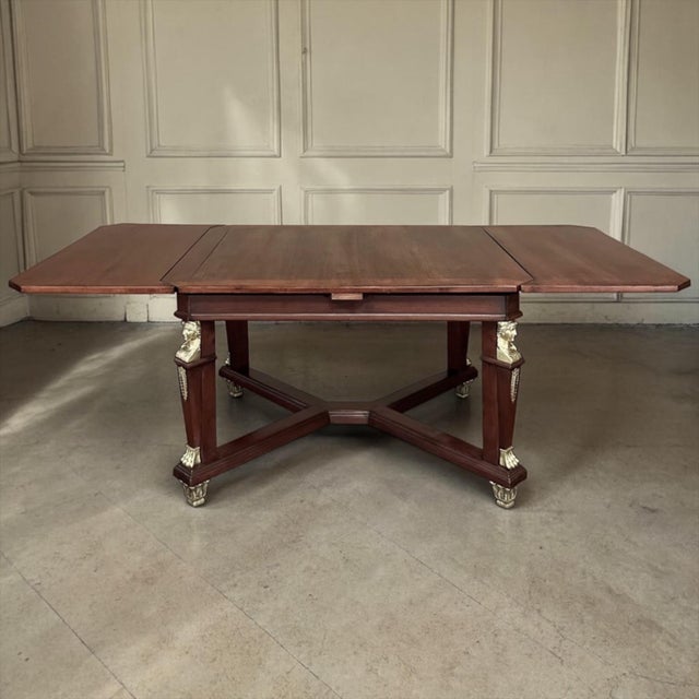 Antique French Empire Mahogany Draw Leaf Dining Table with Bronze Mounts exudes elegance, and is extraordinarily versatile...
