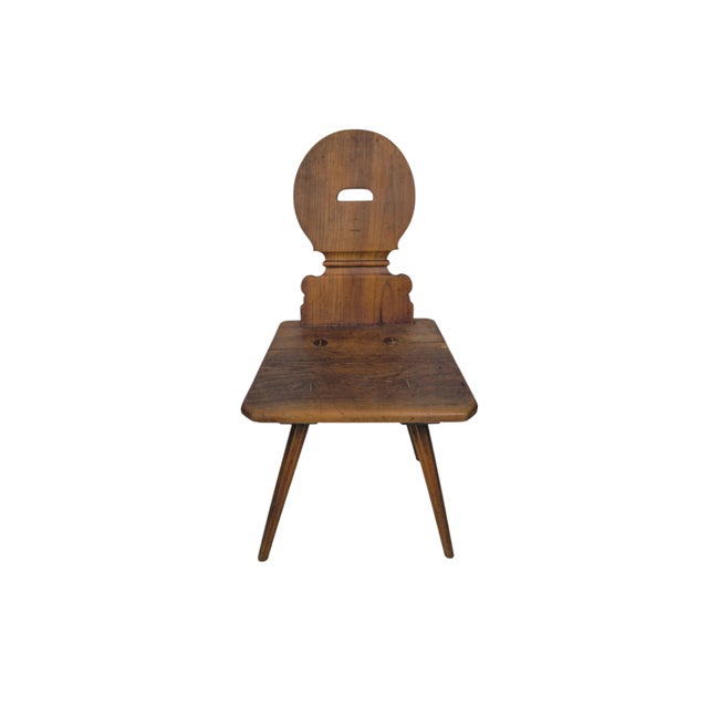 A rustic Swiss Brettstuhl (board chair) or Bauernstuhl, crafted in cherrywood around 1800. The chair is distinguished by...