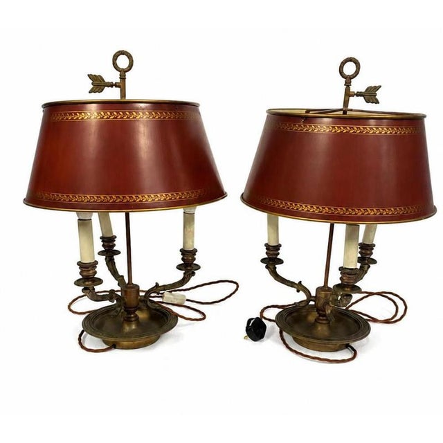 A handsome pair of traditional toleware bouillotte lamps, dating to the early 20th century and inspired by the elegant...