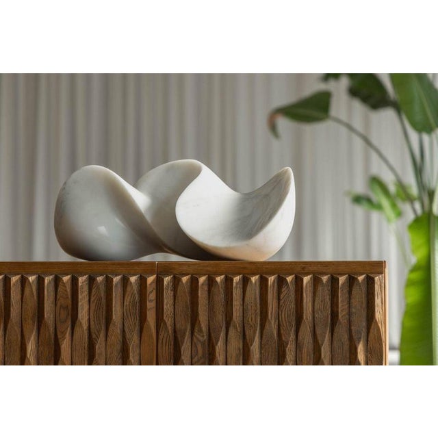 This sculptural object, carved from luminous Carrara marble, presents itself as a quiet yet assured meditation on balance,...