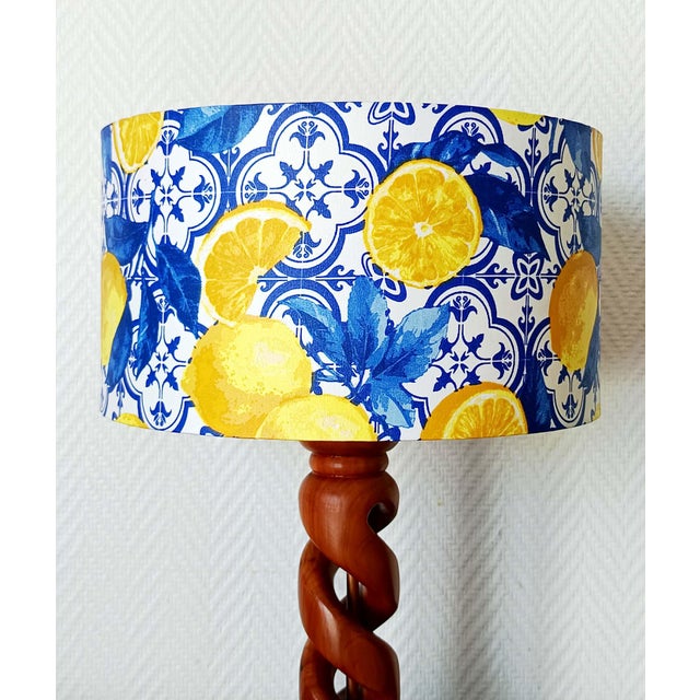 Spiral-shaped walnut lamp base with a custom-made cylindrical lampshade upholstered in a fabric pattern of yellow lemons...