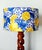 Spiral-shaped walnut lamp base with a custom-made cylindrical lampshade upholstered in a fabric pattern of yellow lemons...