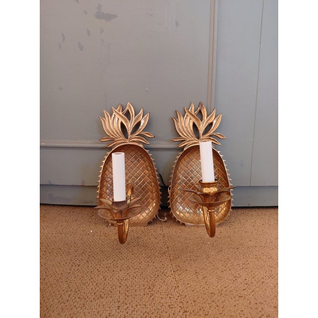 Bring a touch of timeless tropical glamour to your home with this striking pair of vintage Hollywood Regency pineapple...