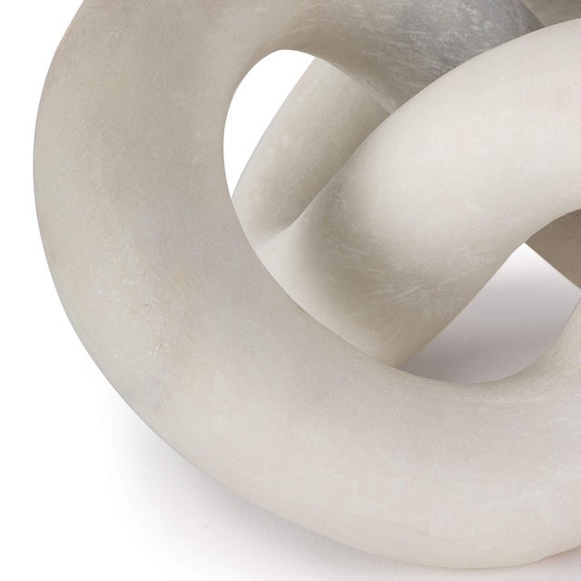 Hand-carved from a single piece of white stone, this abstract sculpture weaves about creating a flowing singular form. Add...