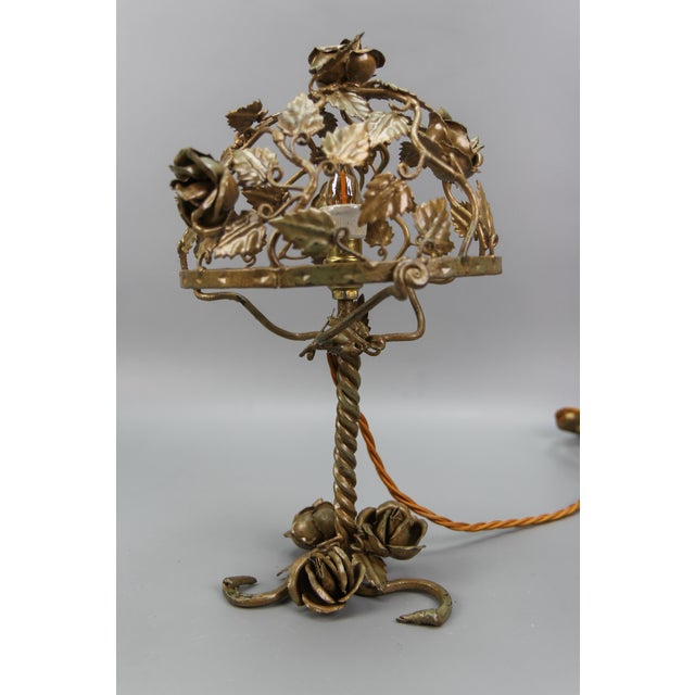 This beautiful and unusual golden color metal floral table lamp features a metal body decorated with roses and leaves. One...