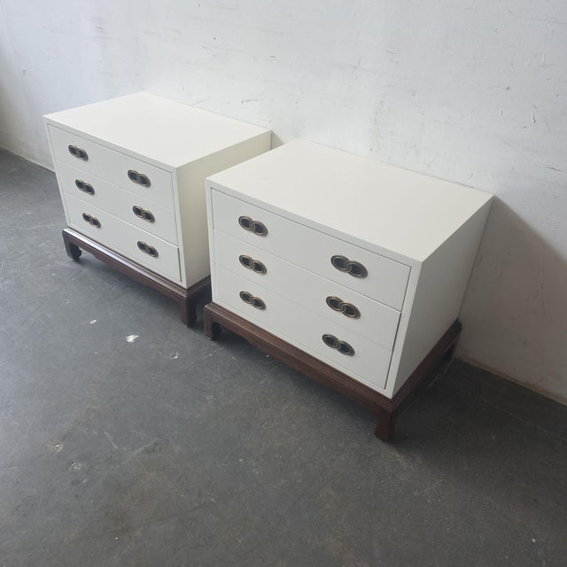 This pair of Henredon end tables features a clean white finish, three spacious drawers, and elegant brass ring pulls. The...