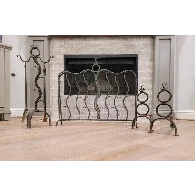 An early 20th century French Art Deco wrought iron fireplace set. Born in France, circa 1910s/early 1920s, featuring...