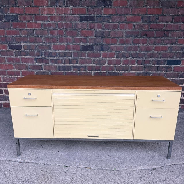 This is a mid century Steelcase tanker credenza. It features four drawers on the side, and a large tambour door finished...