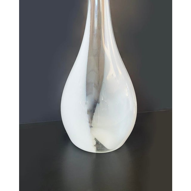 Elegant vase in white and transparent Murano glass characterized by a long neck and a "pear" shape. The set is available...