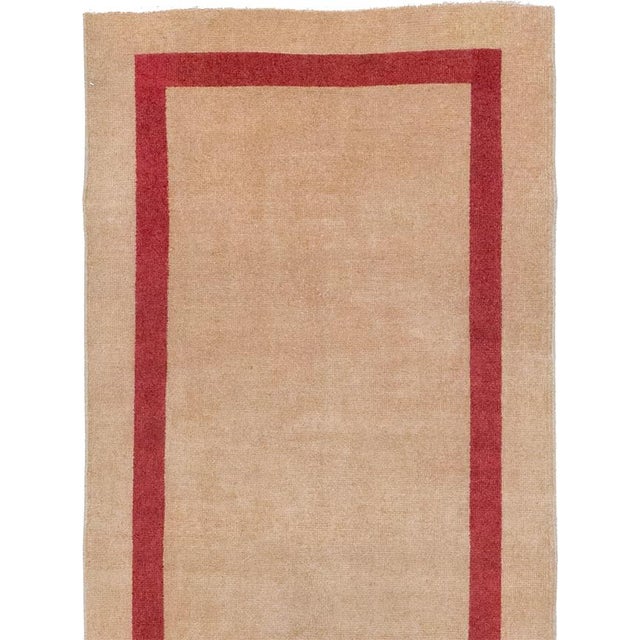 This mid-20th-century Turkish Anatolian runner presents an exceptionally spare composition defined by a warm camel-beige...