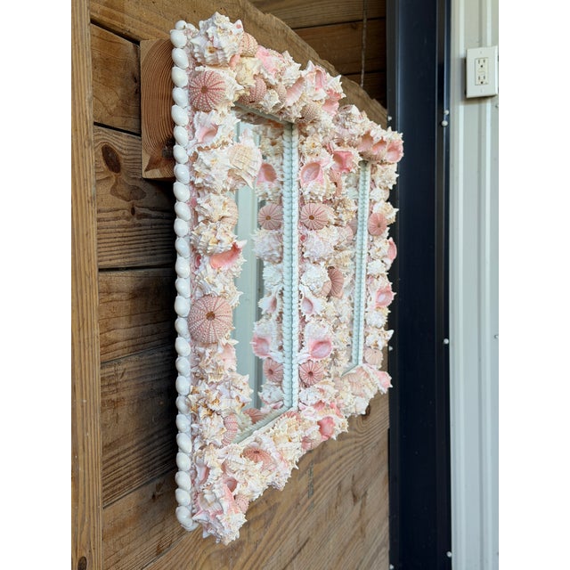 Whimsical custom coastal wall mirrors completely adorned in layers of blush pink and creamy white seashells for the...
