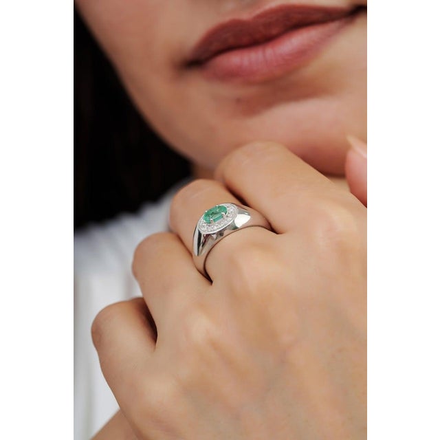 Crafted in 925 sterling silver, this striking ring showcases a 0.52 ct oval-cut emerald accented by 0.14 ct of sparkling...