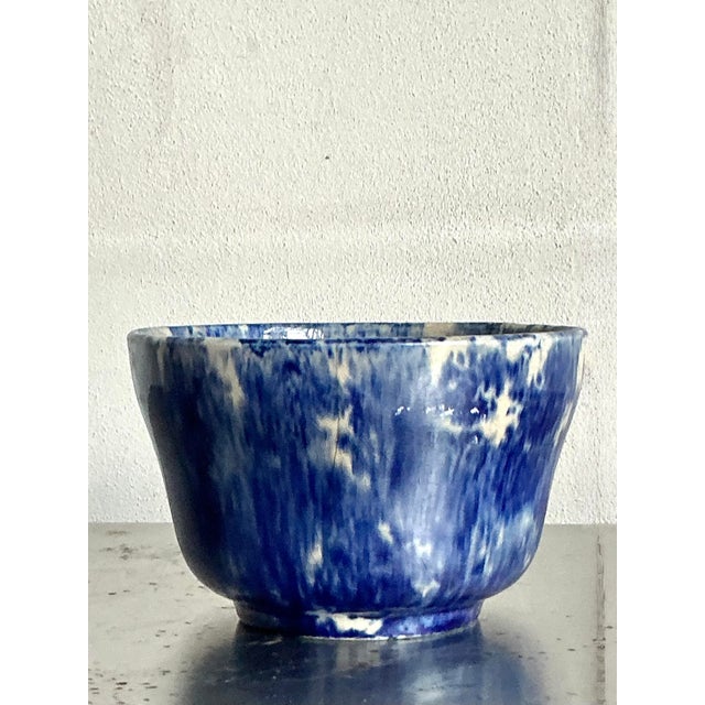 This charming vintage ceramic bowl captures the essence of bohemian artistry with its captivating blue and white splatter...