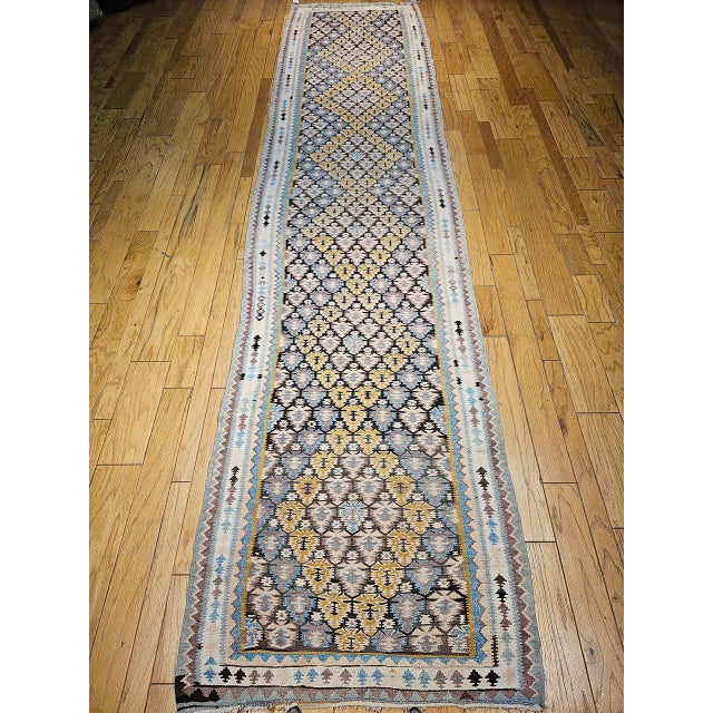 This authentic flat-woven Persian Qazvin kilim features an all over geometric pattern inspired by stylized flower buds,...