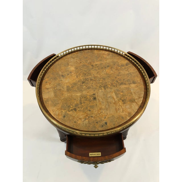 Stunning round mahogany side table by Maitland Smith having handsome caramel faux marble top with lovely brass gallery and...