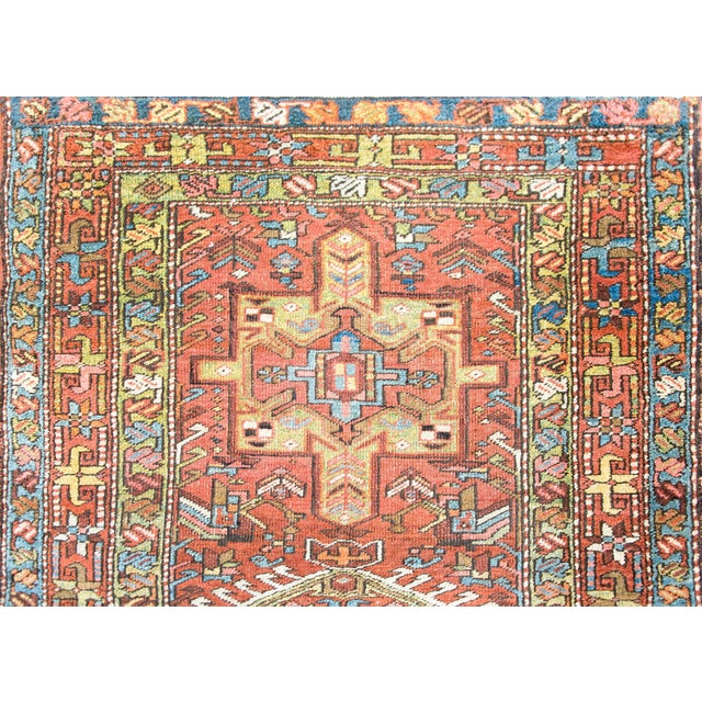 A stunning early 20th century Persian hertz runner with myriad stylized floral medallions woven in pinks, indigos, whites,...