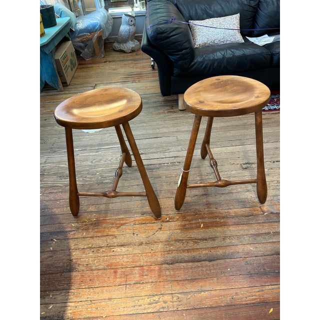 Hand crafted pair of what we believe is solid birch, 3 legged stools having organically shaped concave seats, club shaped...